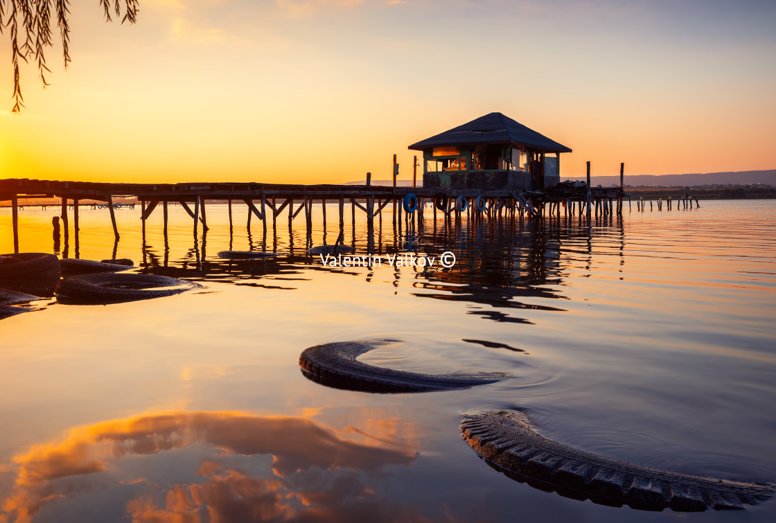 "Sunset over the sea lake and old wooden pier, romantic travel de" stock image