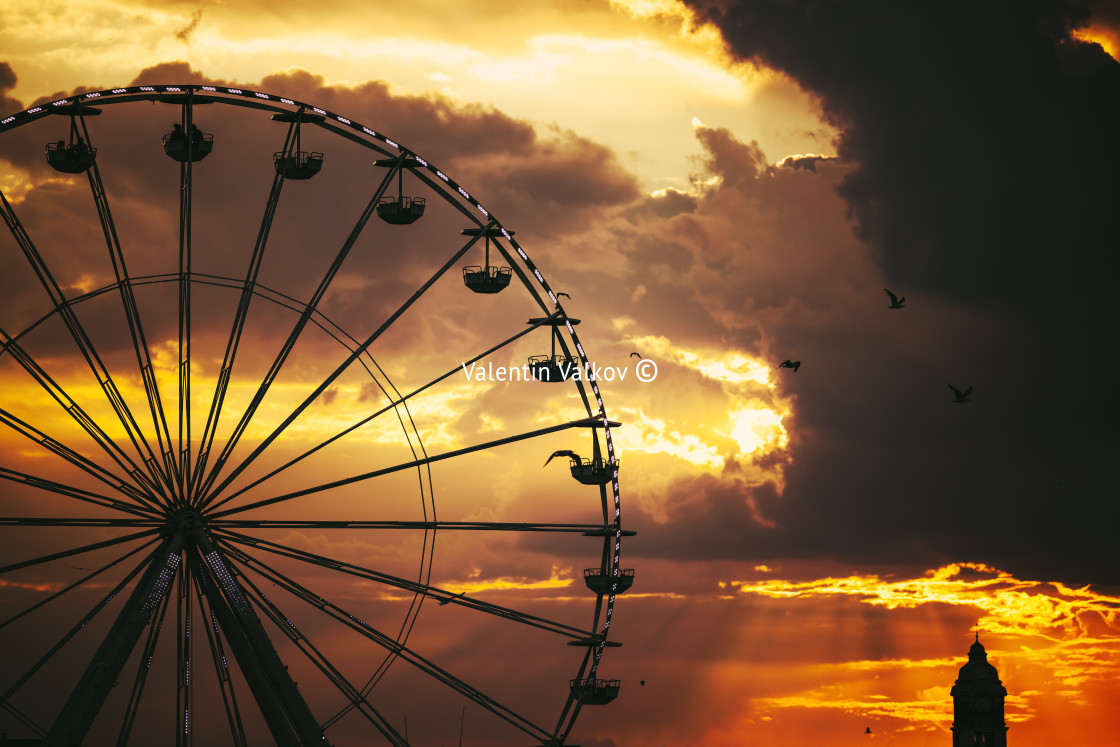 "Ferris Wheel in amusement park and scenic sunset clouds in sky a" stock image