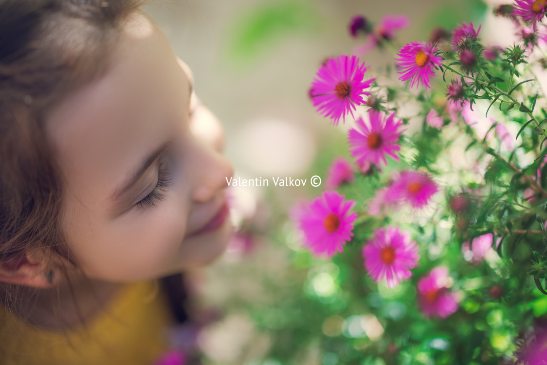 "Beautiful girl farmer woman smells the aroma of blooming pink fl" stock image