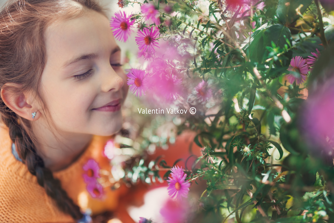 "Beautiful girl farmer woman smells the aroma of blooming pink fl" stock image