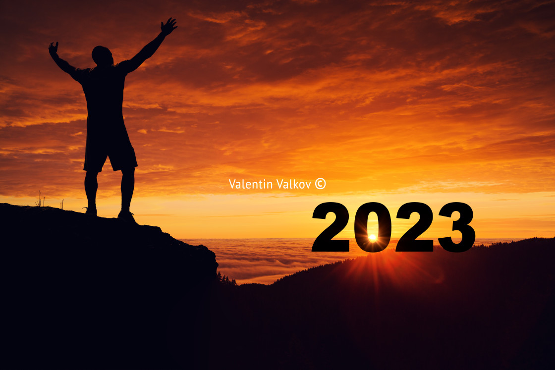 "Man silhouette on the mountain top watching the sunrise and 2023" stock image