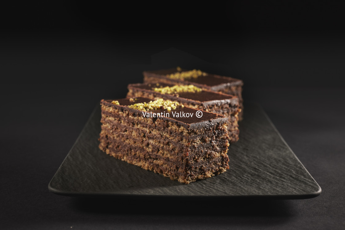 "Chocolate cake with walnuts and pistachio isolated on black back" stock image