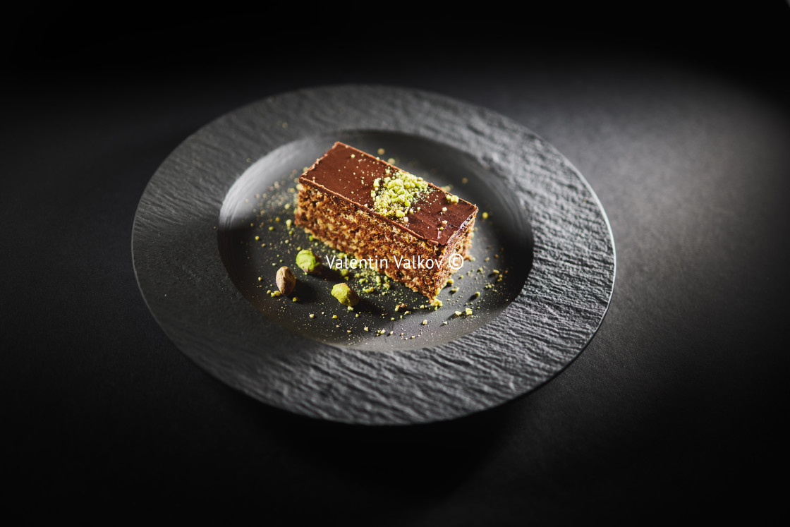 "Chocolate cake with walnuts and pistachio isolated on black back" stock image