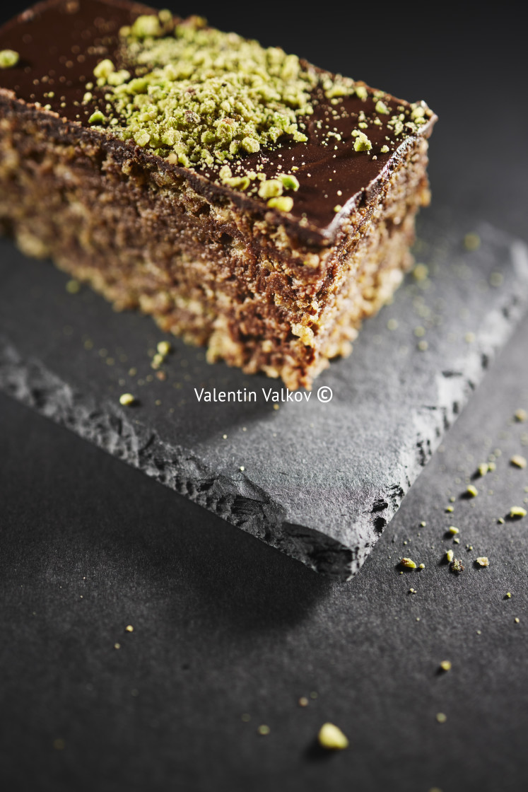 "Chocolate cake with walnuts and pistachio isolated on black background. Pastry from homemade bakery" stock image