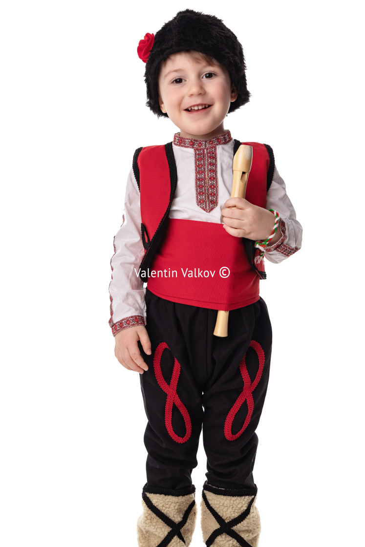 "Bulgarian boy in traditional folklore costumes with spring flowers snowdrop and handcraft wool bracelet martenitsa symbol of Baba Marta" stock image