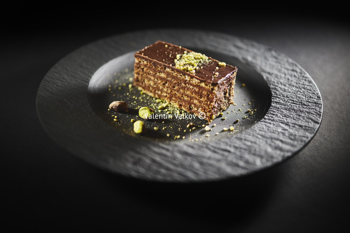 "Chocolate cake with walnuts and pistachio isolated on black background. Pastry from homemade bakery" stock image