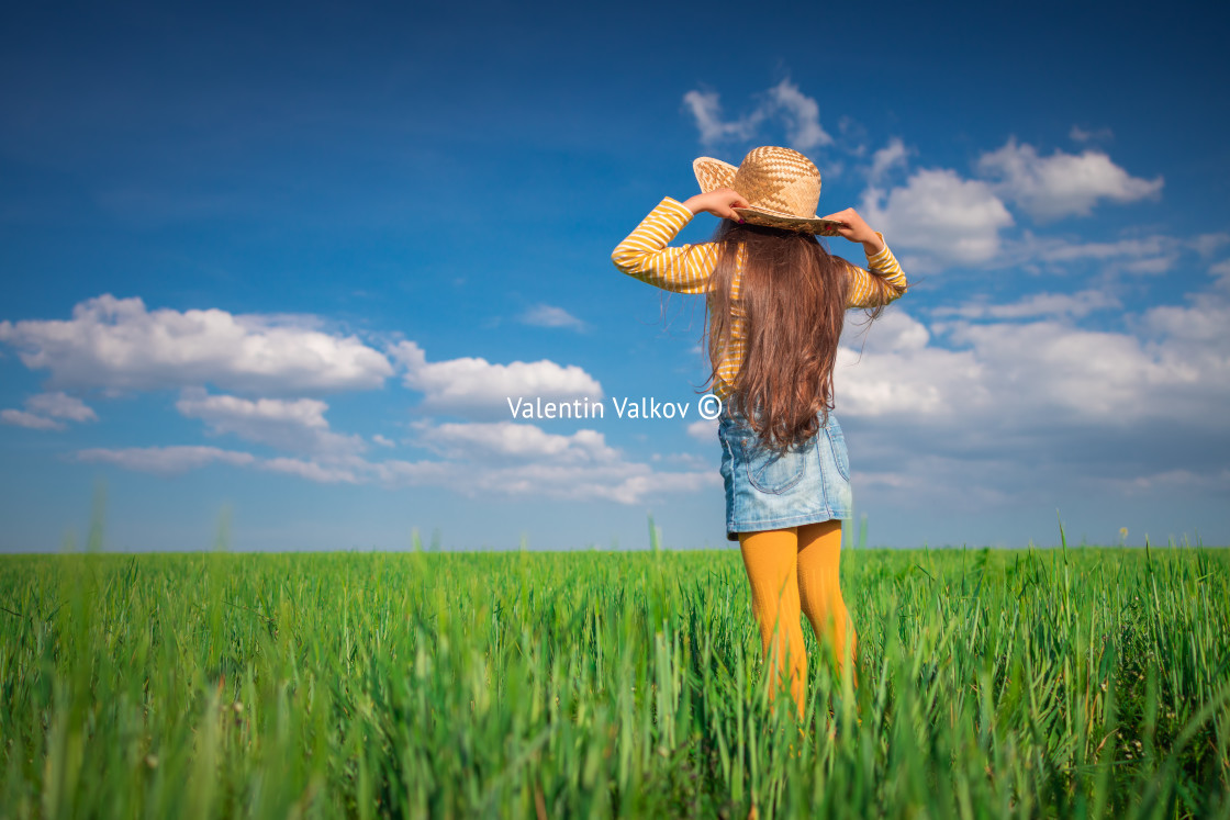 "Green wheat field landscape and happy farmer girl playing with straw hat" stock image