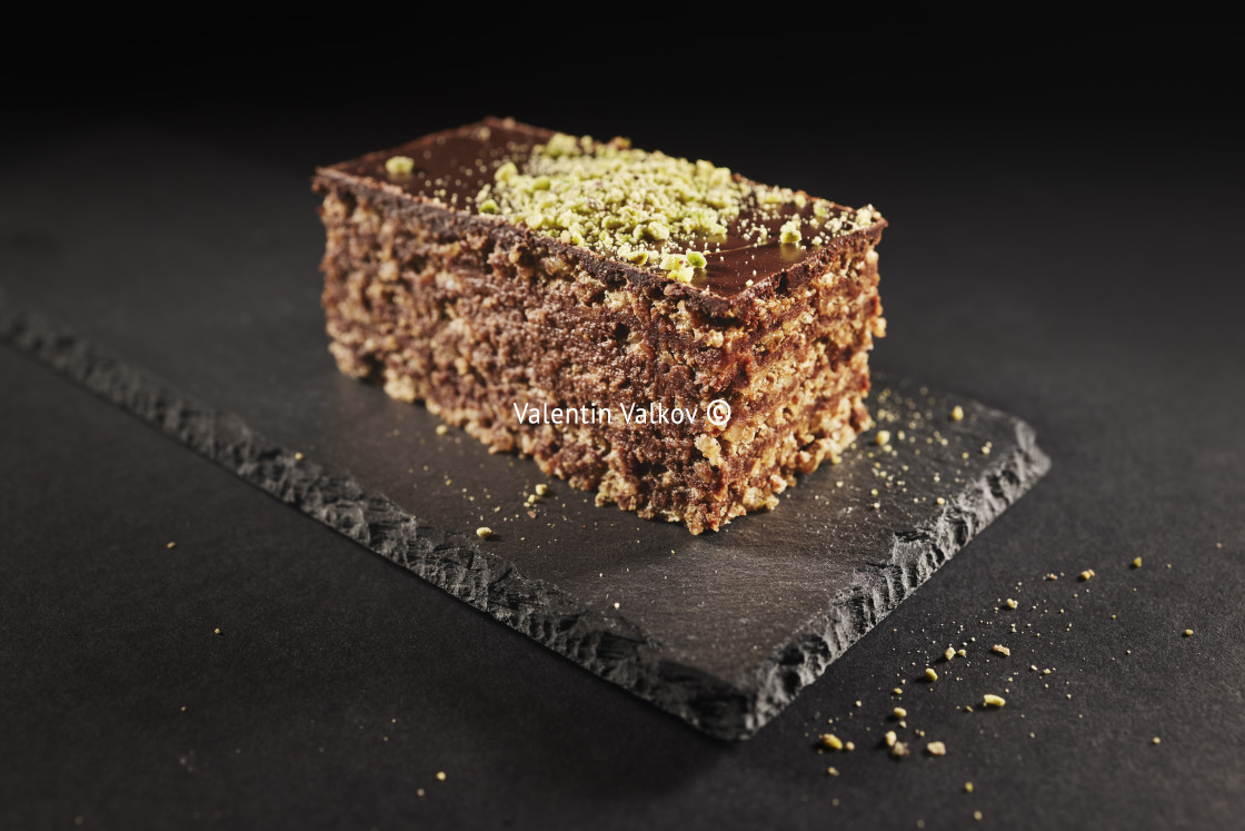 "Chocolate cake with walnuts and pistachio isolated on black background. Pastry from homemade bakery" stock image