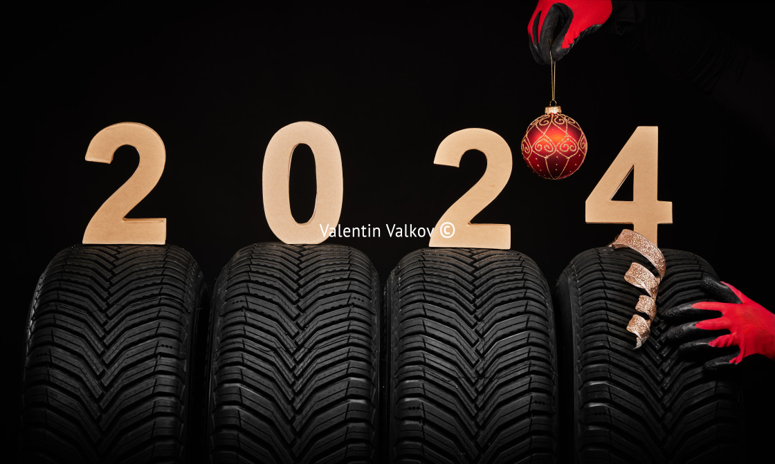 "Winter car tires service and thumbs up hands of mechanic and text 2024 happy new year on black background" stock image