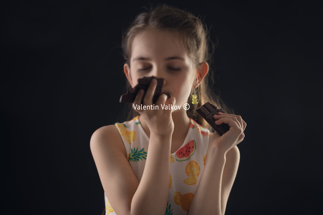 "Chocolate and pretty hungry little woman portrait. Beautiful girl ready to eat chocolate bar." stock image