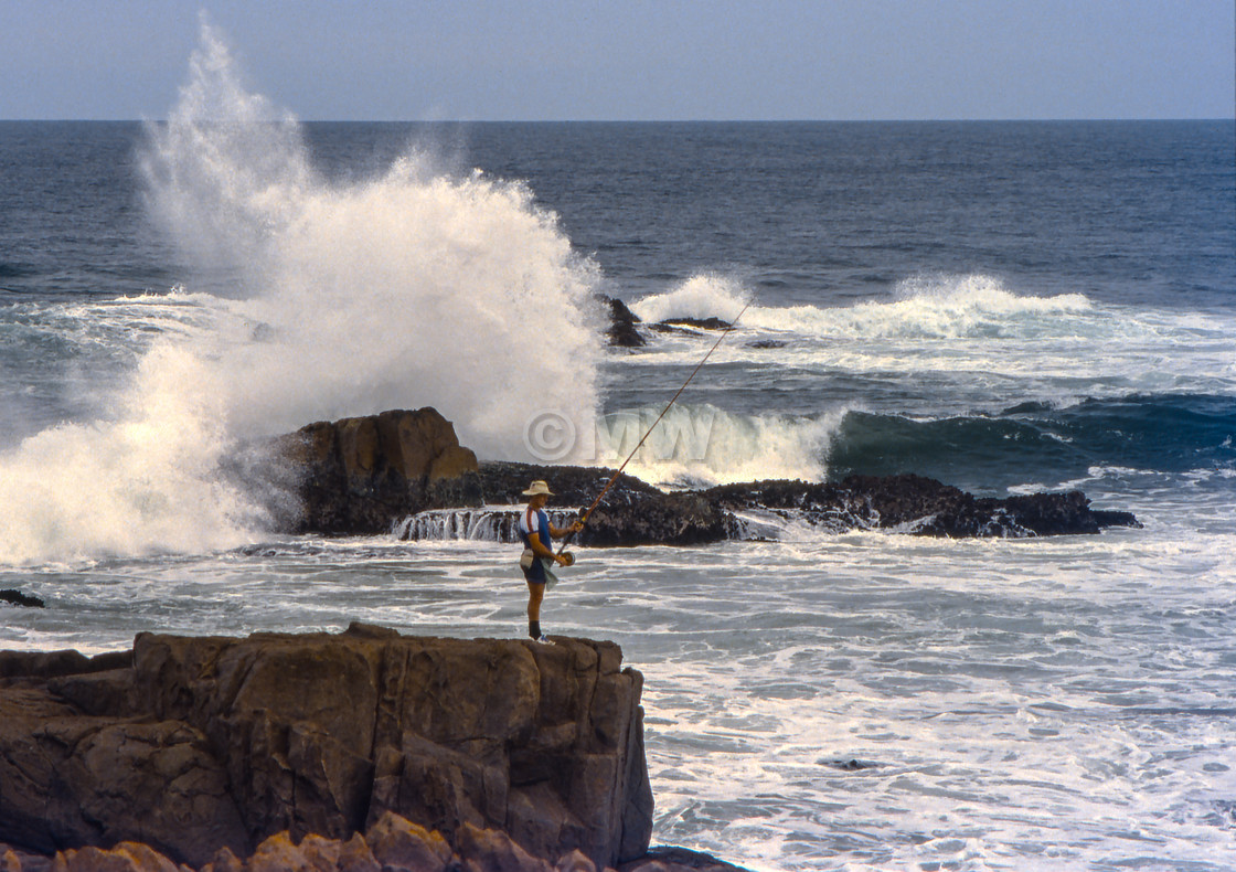 "Rock fisherman with big waves" stock image