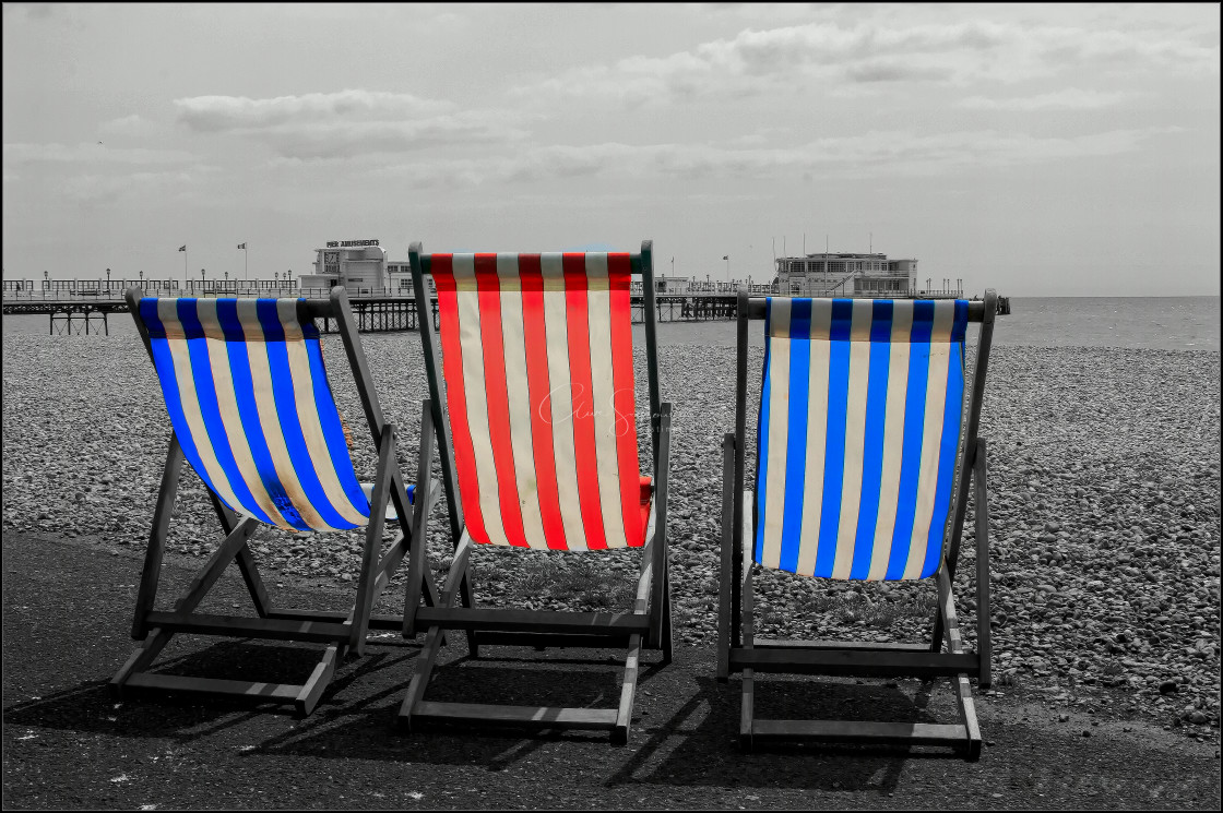 "Beach Scene with 3 coloured deck chairs." stock image