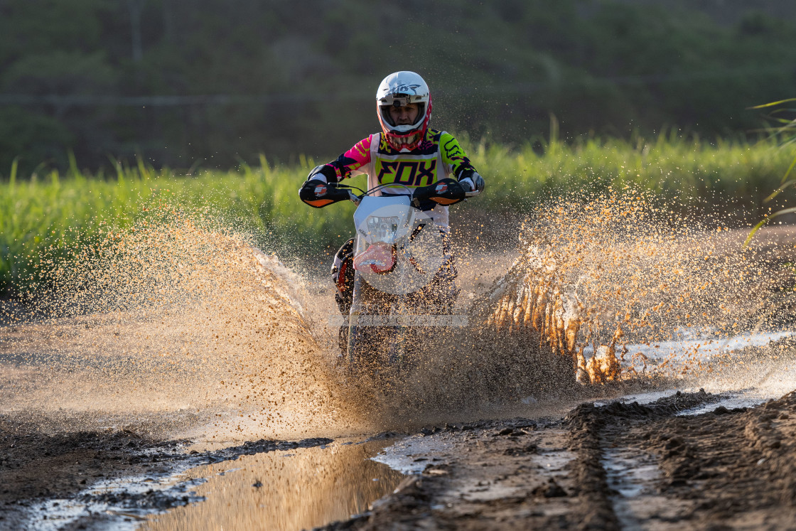 "Motorcycle riding through mud puddle" stock image