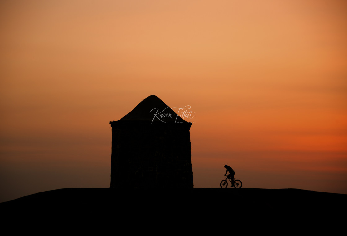 "A Silhouhette Cyclist At Sunset" stock image