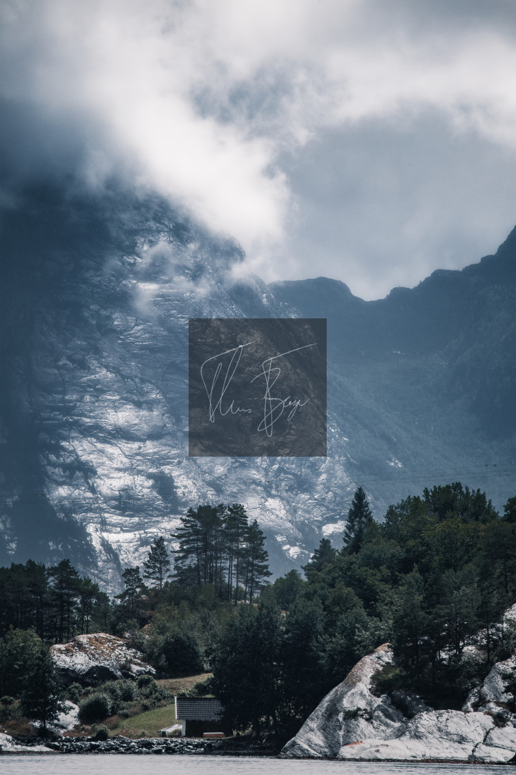 "A wet mountainside along the Hardangerfjord in Norway illuminated by the sun." stock image