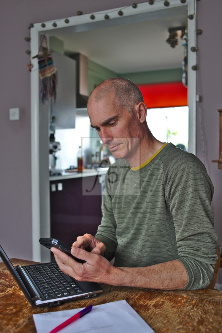 "A man working at home at kitchen table" stock image