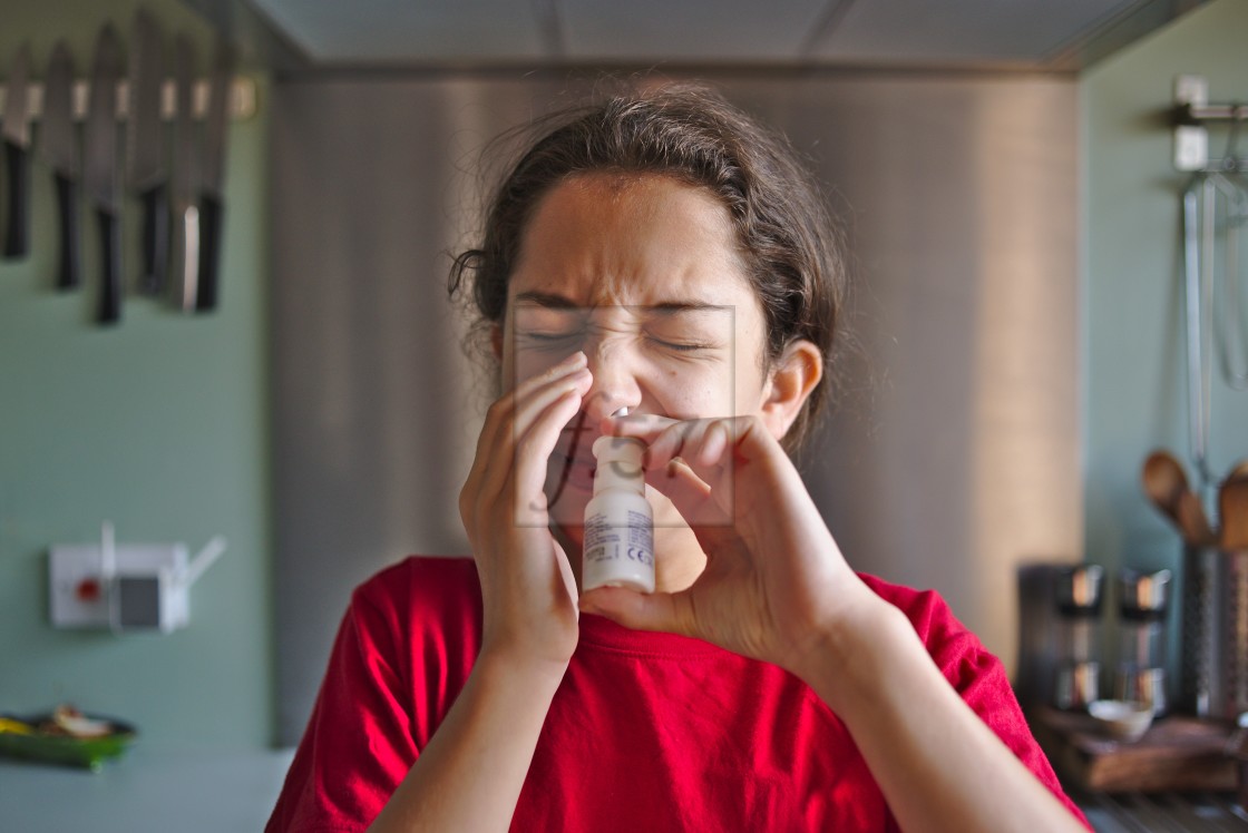 "A child using nasal spray hayfever treatment" stock image