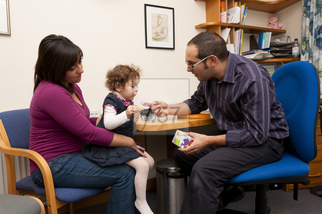 "GP Doctor rewards child patient with stickers for her during a consultation." stock image