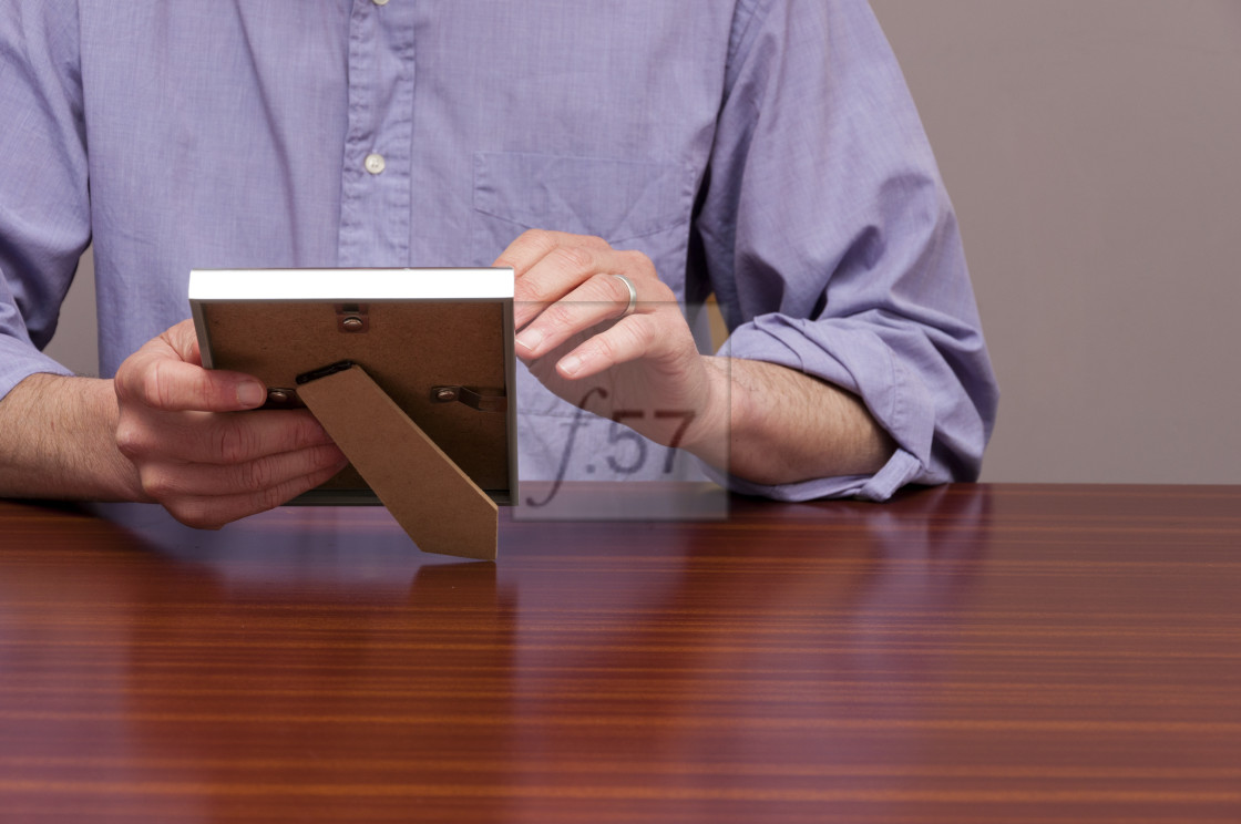 "Bereavement. Bereaved man holding picture frame looking at photo." by HD57 lifestyle stock photography - $29.40 "Bereavement. Bereaved man holding picture frame looking at photo." stock image