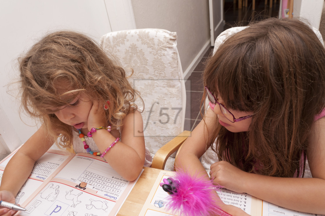 "Sisters, four and five years old learning together with activity books." by HD57 lifestyle stock photography - $29.40 "Sisters, four and five years old learning together with activity books." stock image