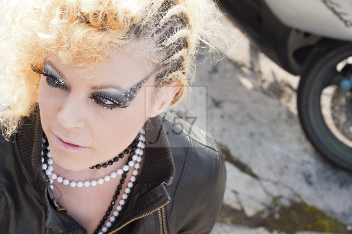 "Woman in black leather jacket with striking hair and makeup." stock image