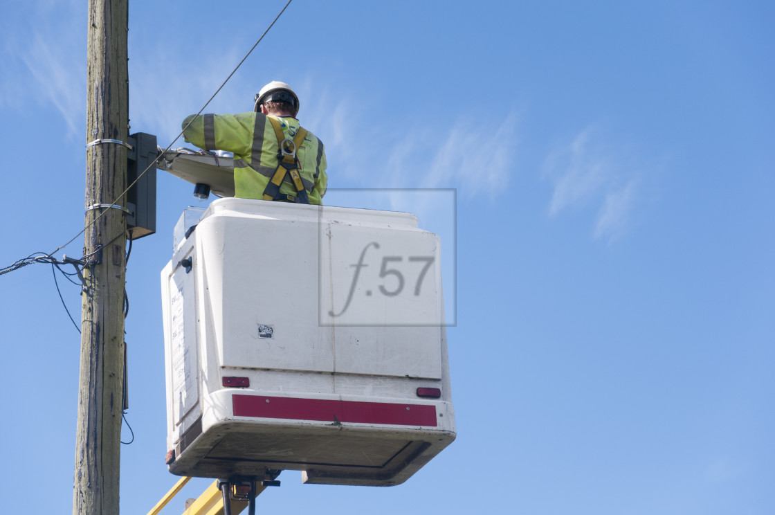 "Worker in cherry picker working on street light." stock image