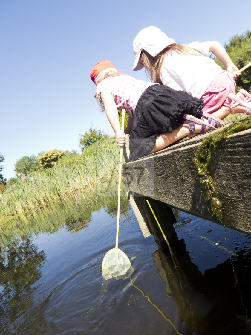 "Children play with fishing nets from jetty" stock image