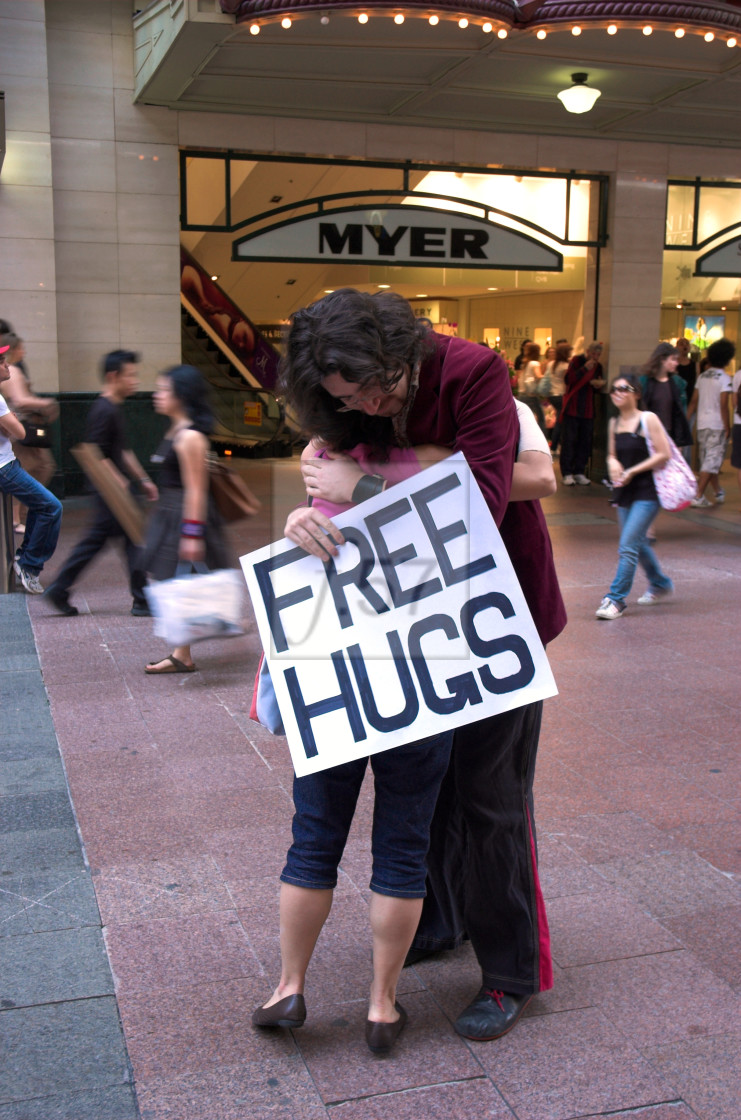 "Juan Mann, the originator of the Free Hugs Campaign, gives a passing woman a hug in Sydney, Australia." stock image