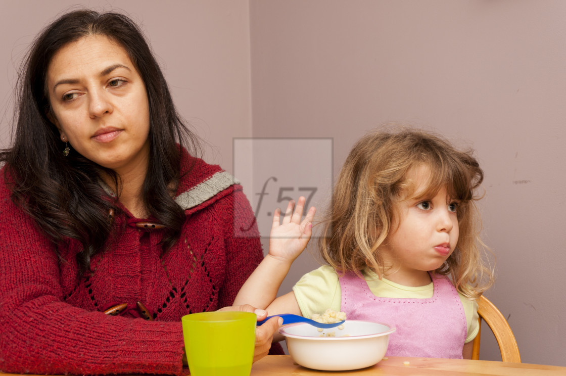 "Fussy eater. Mother trying to feed her four year old daughter." stock image