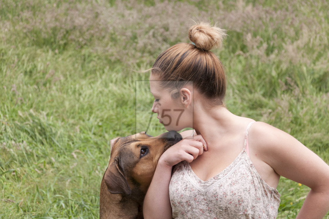 "Young woman playing with pet dog" stock image