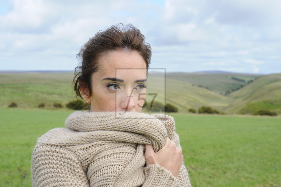 "Attractive brunette woman wrapped in woolen cardigan" stock image