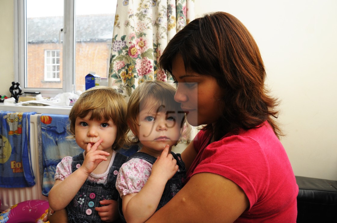 "Young Mum at home with twin daughters" stock image