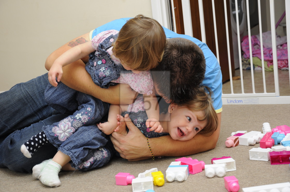 "Dad playing with his young children" stock image