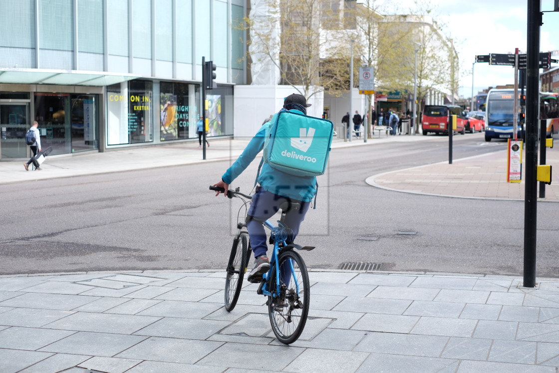 "Deliveroo food delivery cycle courier in central Exeter, Devon UK" stock image