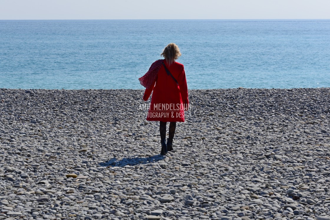 "Sea sand and a woman with a red coat" stock image