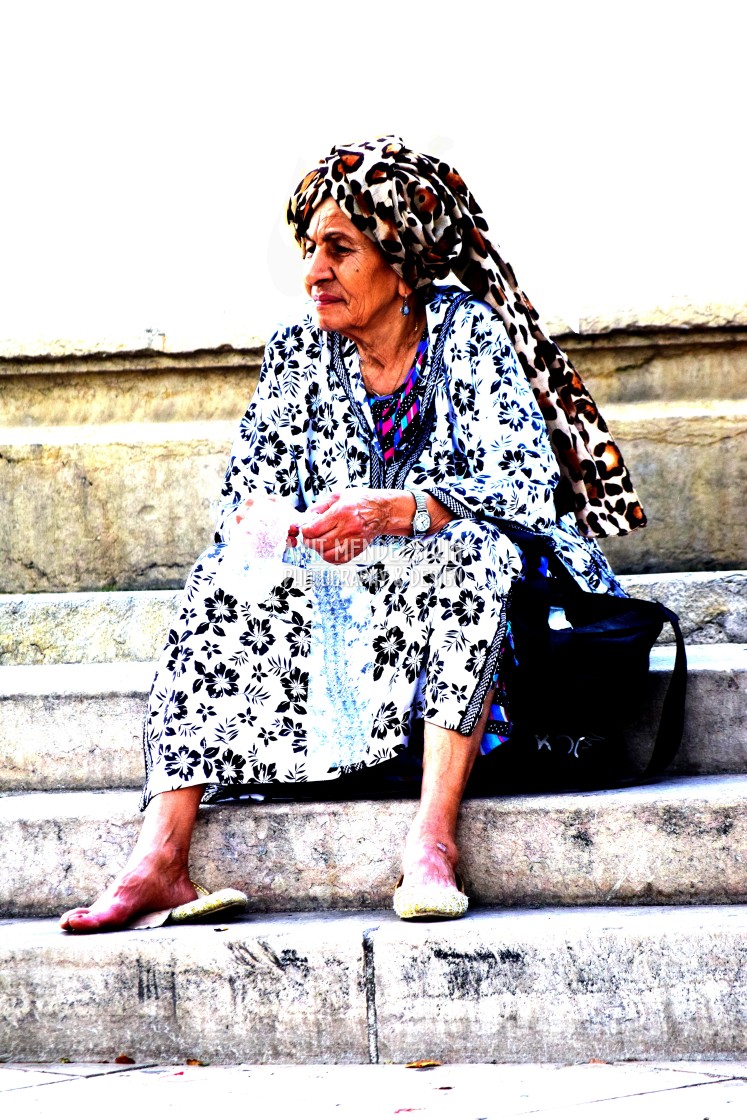 "An old woman by the fountain" stock image