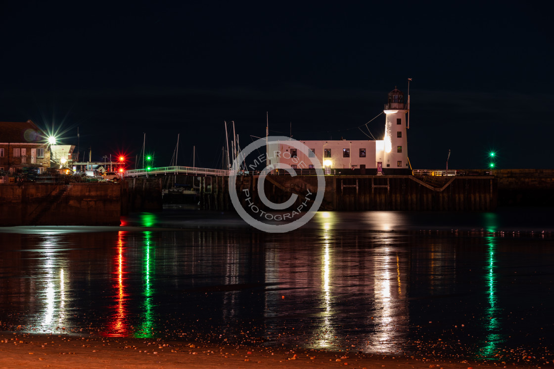 "Nighttime reflection of Scarborough Harbour's Lighthouse" by Melrose Photography - £10.00 "Nighttime reflection of Scarborough Harbour's Lighthouse" stock image