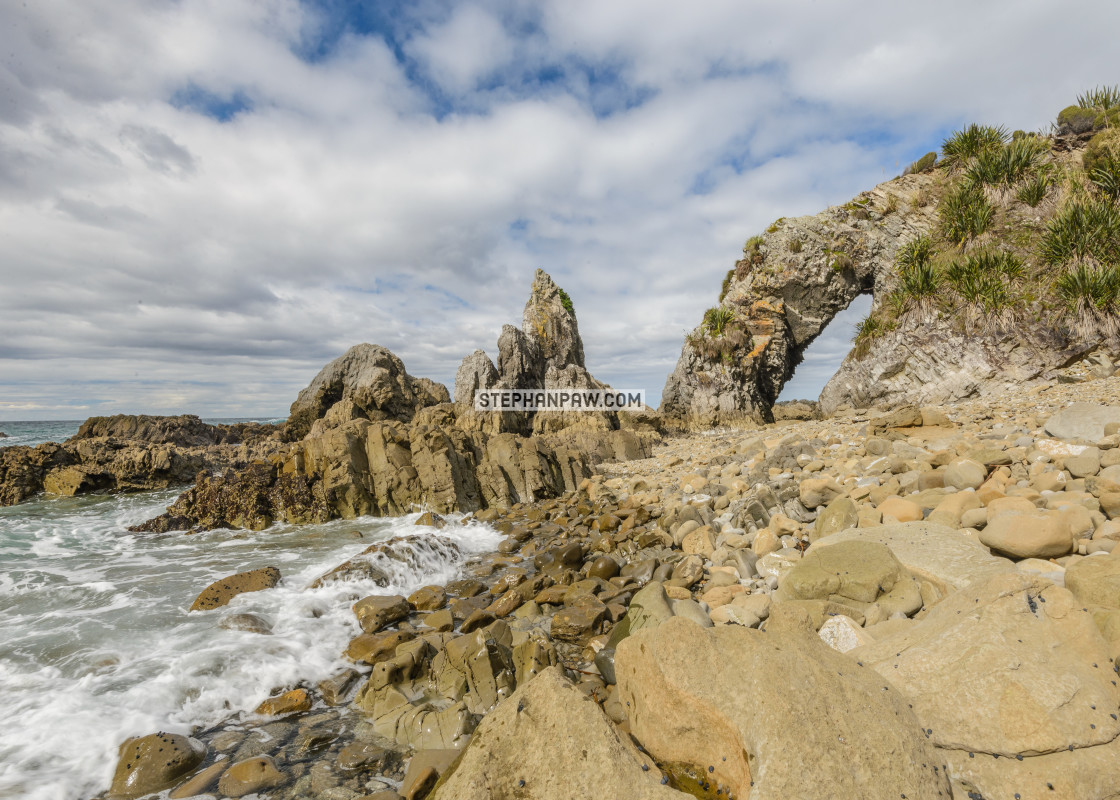 "Natural archway at Langs Beach // Northland, New Zealand" stock image