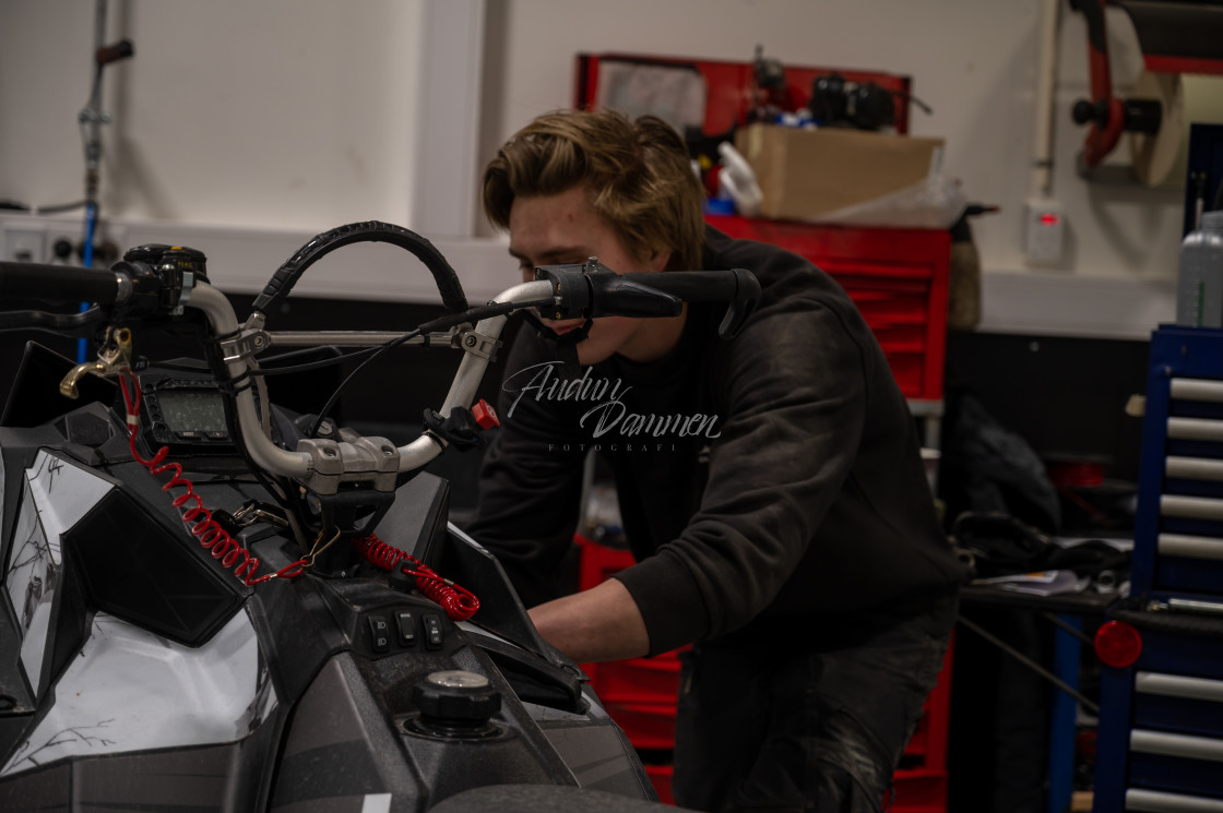 "Mechanic repairing snowmobile" stock image