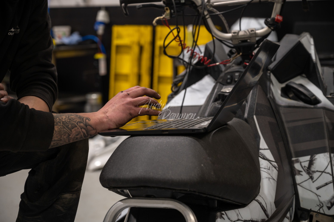 "Mechanic repairing a snowmobile" stock image