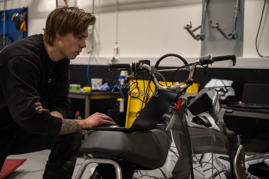 "Mechanic repairing a snowmobile" stock image