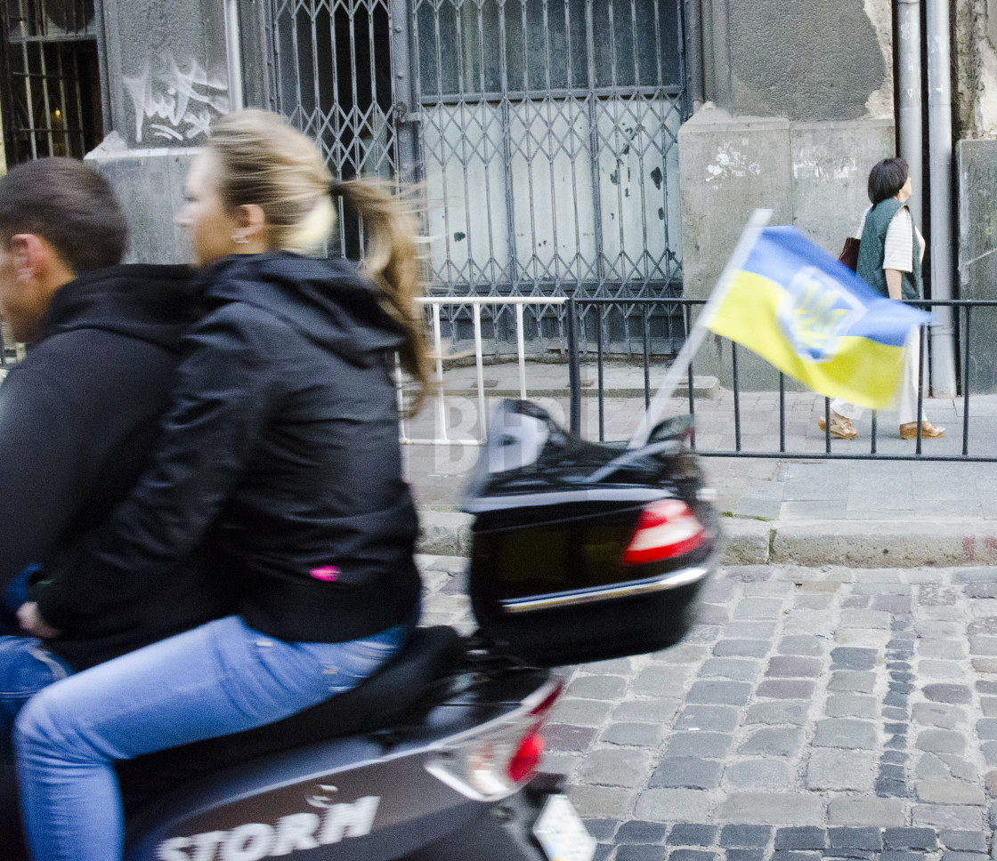 "Ride on moped with Ukrainian flag" by Brendan Howard - £10.00 "Ride on moped with Ukrainian flag" stock image