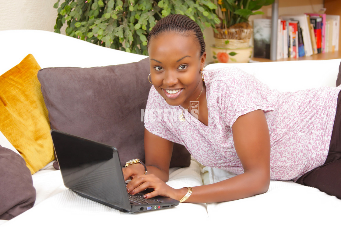 "Happy African American young woman using a laptop" stock image