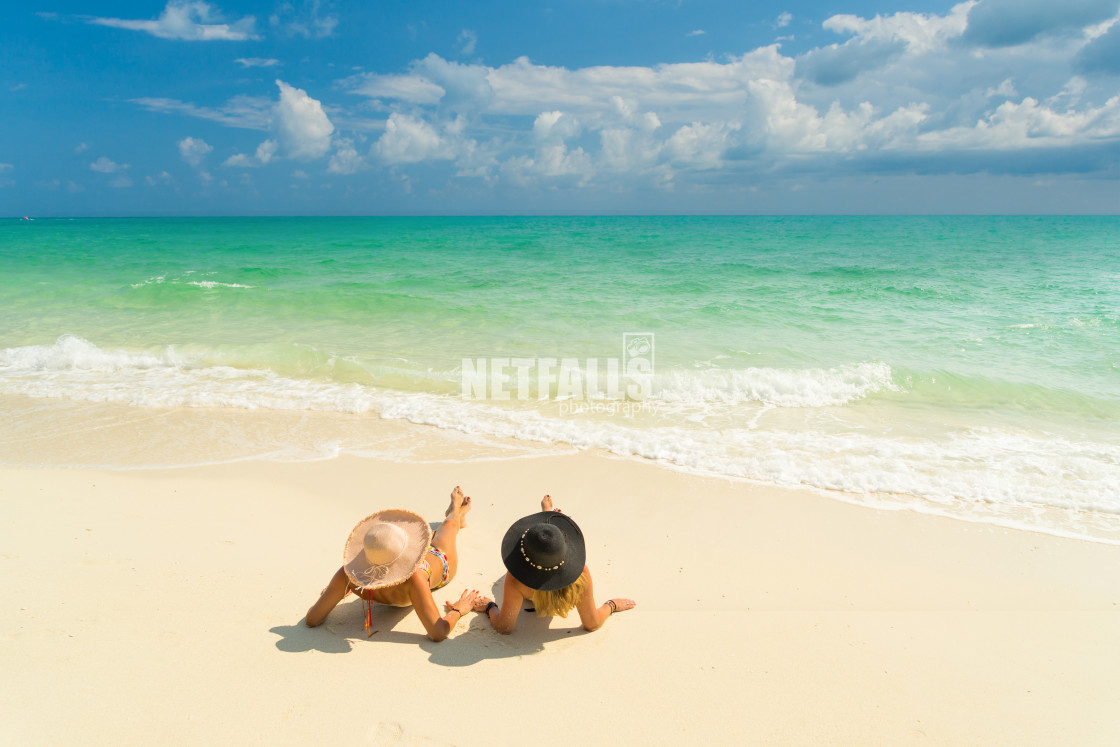 "Sexy bikini body of two women enjoy the sea by laying down on sand of beach..." stock image