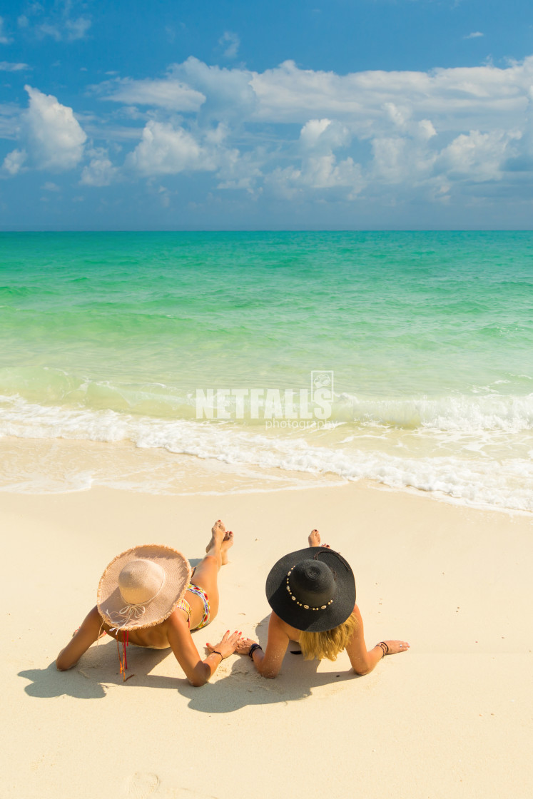 "Sexy bikini body of two women enjoy the sea by laying down on sand of beach..." stock image