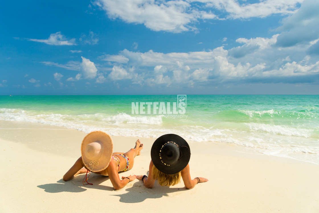 "Sexy bikini body of two women enjoy the sea by laying down on sand of beach..." stock image