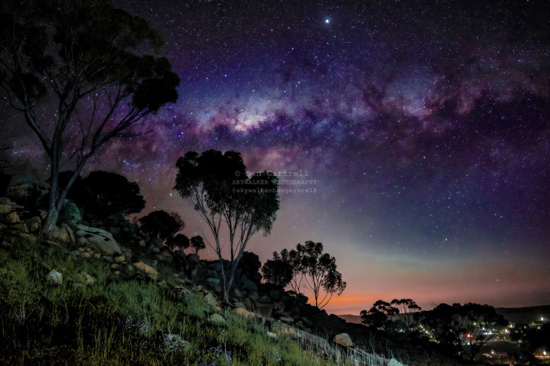 "milky way over small town with trees" stock image