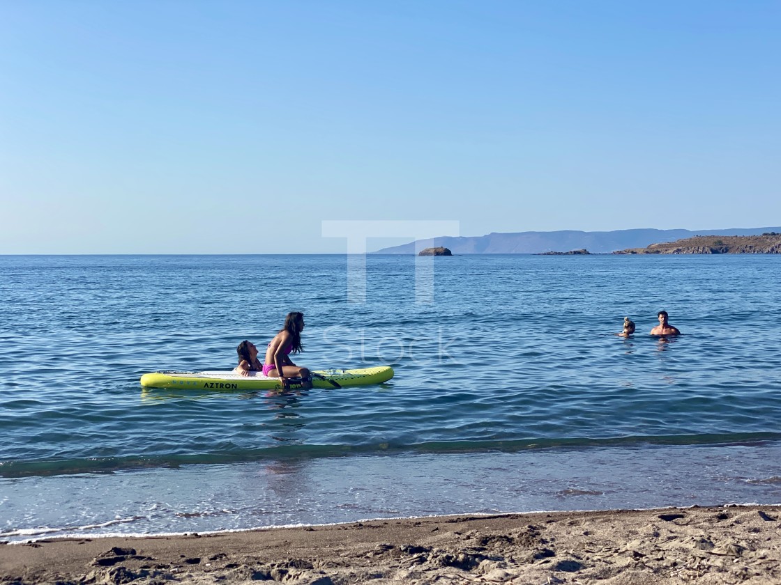 "Young woman wearing a pink bikini sitting relaxing with friend sup board at sea." by TTStock - $7.46 "Young woman wearing a pink bikini sitting relaxing with friend sup board at sea." stock image
