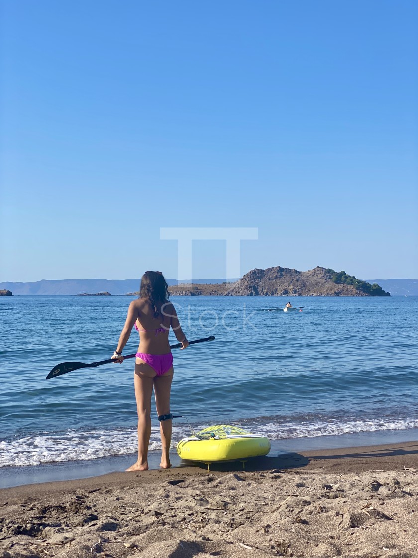 "Young woman wearing a pink bikini standing on the beach with a yellow sup board attached." by TTStock - $7.54 "Young woman wearing a pink bikini standing on the beach with a yellow sup board attached." stock image