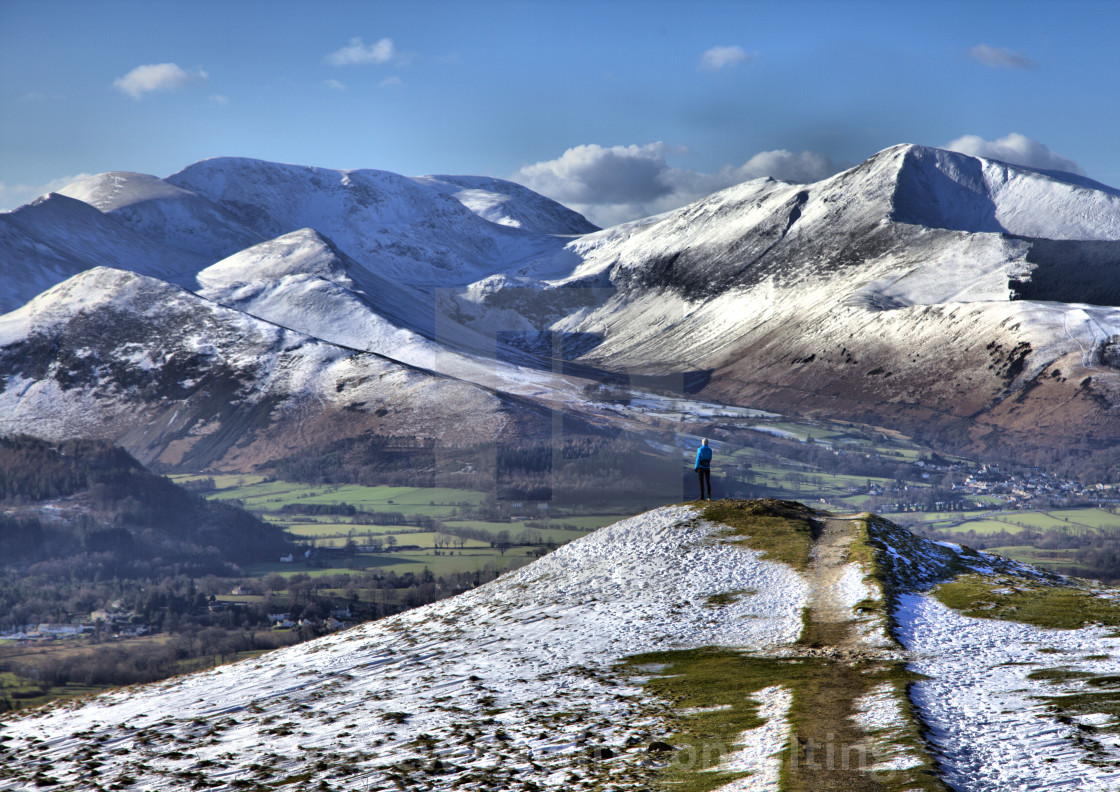 "Lone fell runner on the edge of a snowy Latrigg Fell" stock image